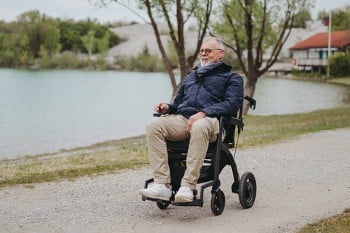 Man driving an electric wheelchair in a parc