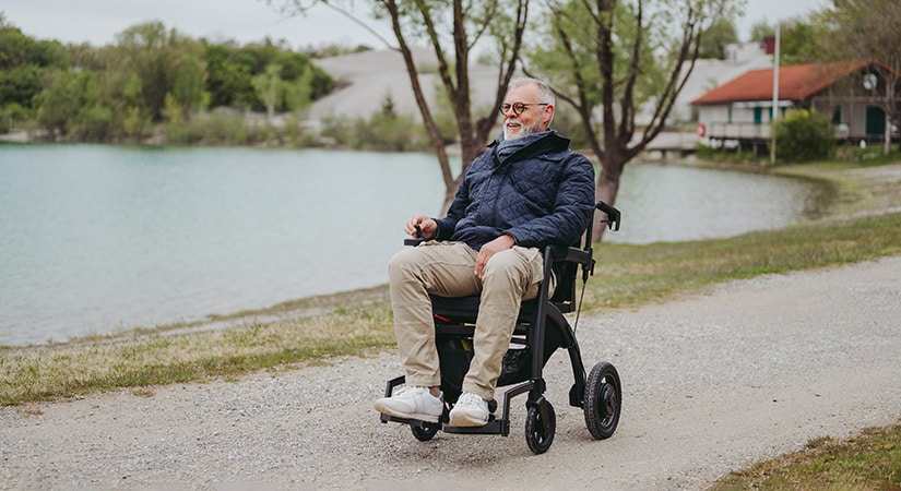 Man driving an electric wheelchair in a parc